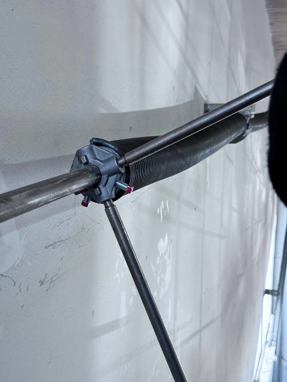 Torsion spring on the shaft with winding bars during a garage door spring repair